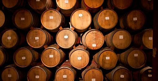 Des fûts superposés dans une cave à vin.