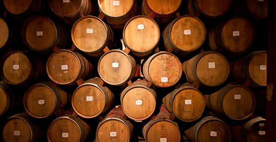 Des fûts superposés dans une cave à vin.