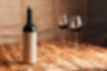 Red wine bottle, two glasses, wooden table