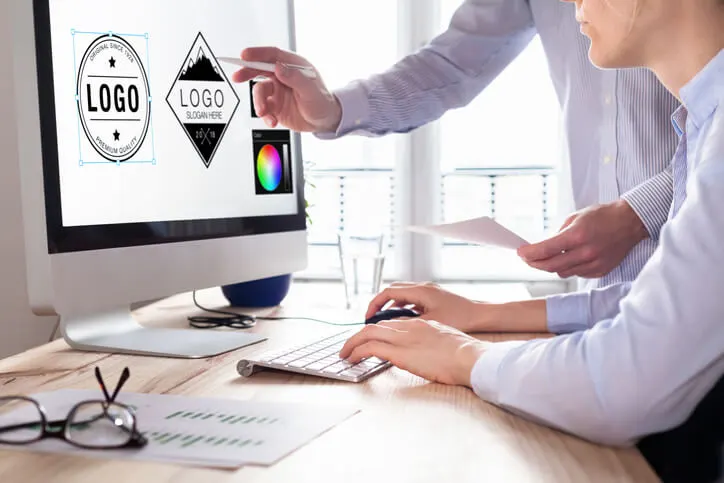 Dos personas ven logotipos en una imac
