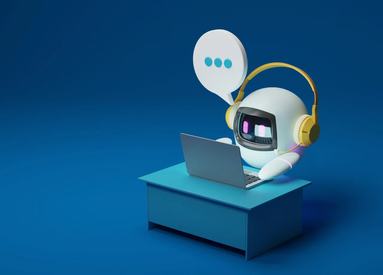 Un chatbot sentado en un escritorio azul frente a una laptop