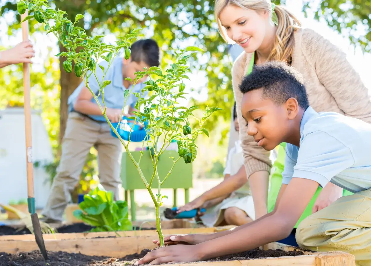 Maestra enseña a niños a plantar árboles