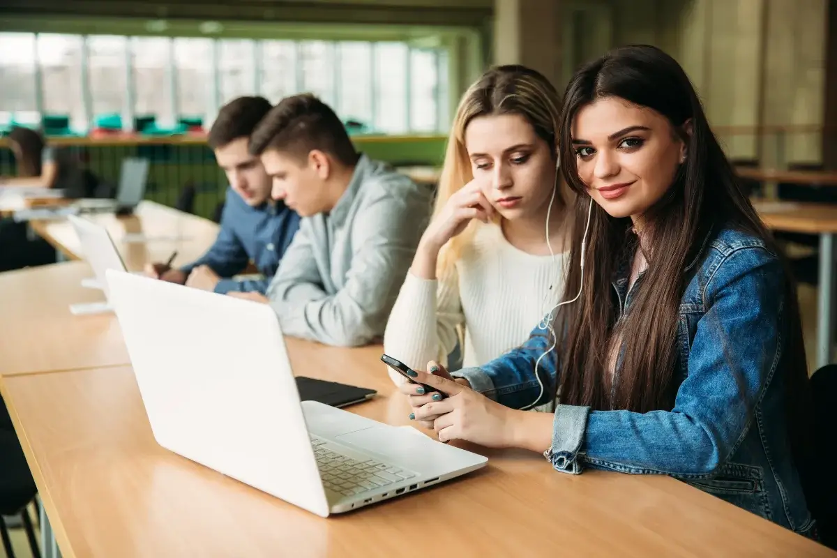 Alumnos universitarios en pupitres frente a laptops