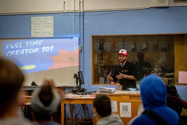 Una clase con un maestro joven que usa gorra