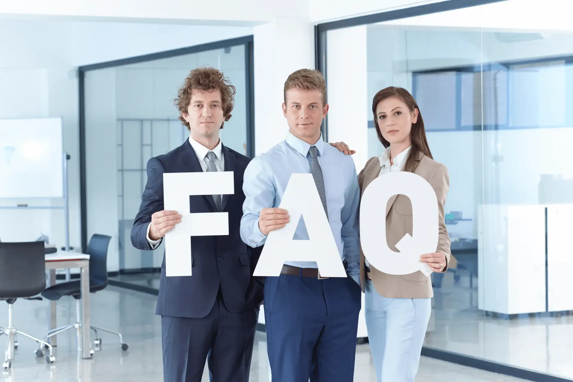 Tres personas vestidas formalmente sosteniendo letras que forman la palabra "FAQ"