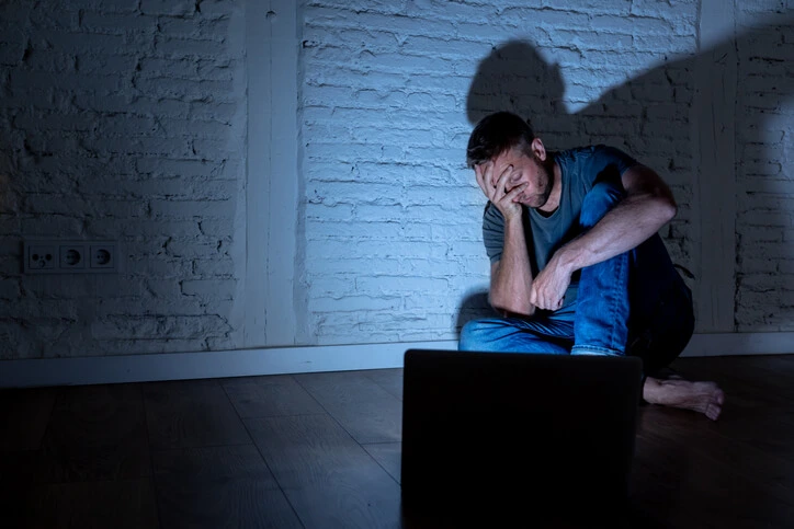 Hombre preocupado frente a una laptop