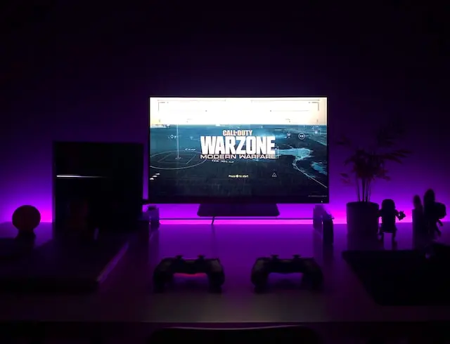 Televisión muestra Call of Duty Warzone junto a una consola PS4