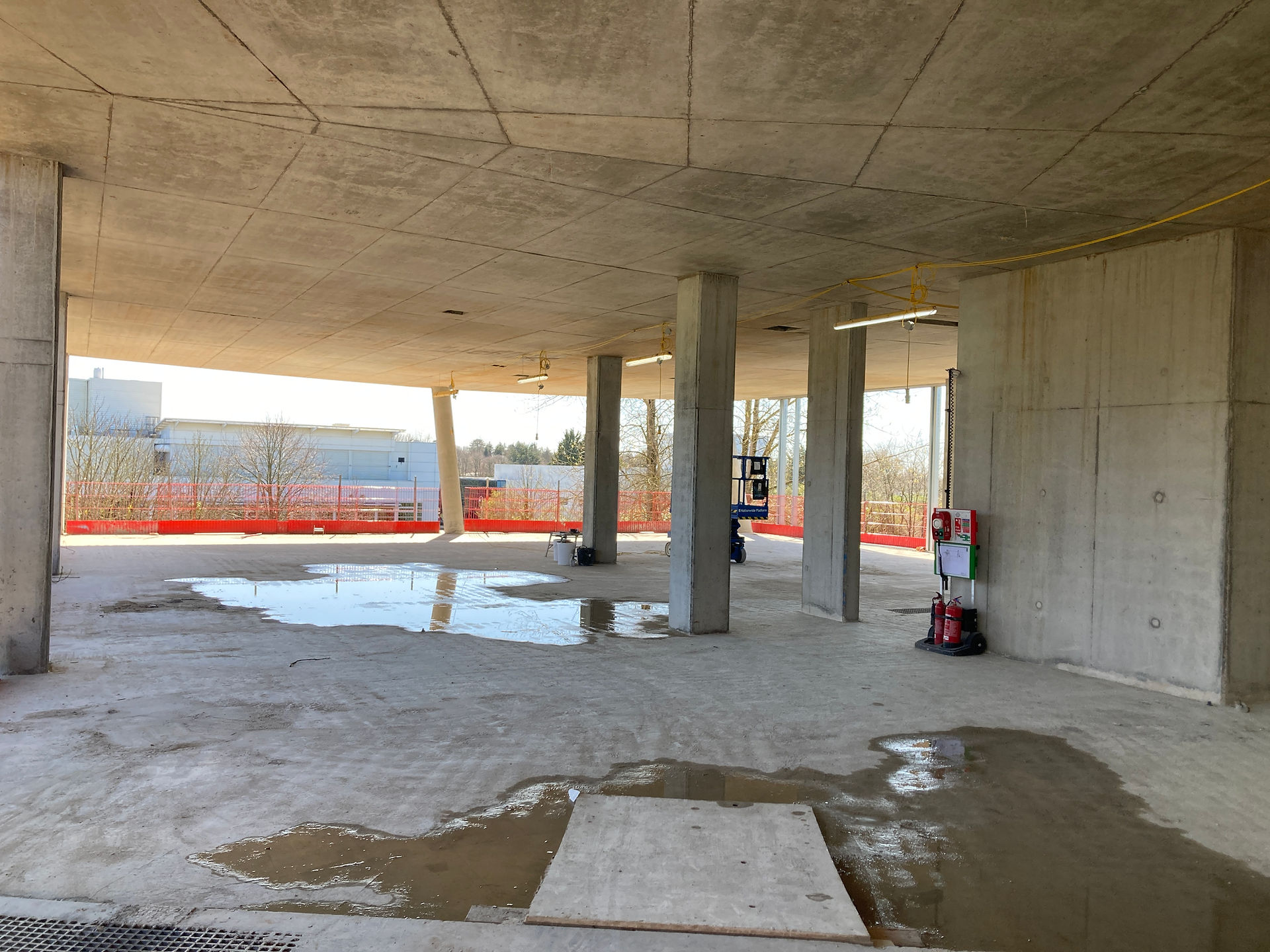 Interior view of a completed floor plate at Infinity Labs, showing the exposed cast-in-situ reinforced concrete columns, soffits, and open-plan laboratory floor space under construction.
