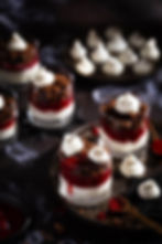 Halloween Dessert im Glas, rotes Beerenmus mit Skyr und Schokobröseln, stimmungsvolle Foodfotografie in Rot und Schwarz.