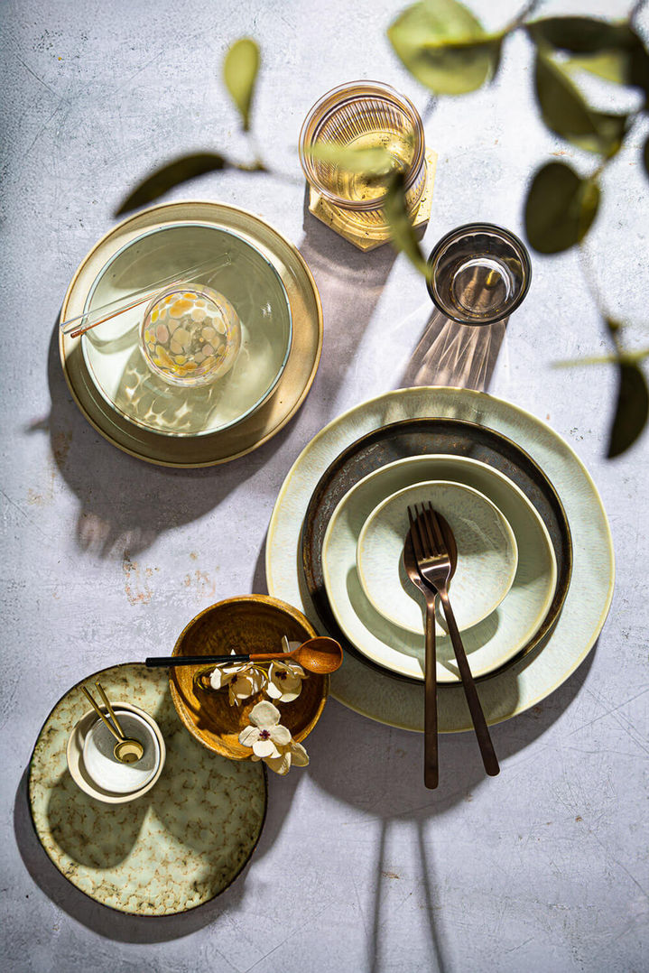 Probsüberischt mit kräftigem Lichtsetting. Tabel-Top Aufnahem mit verschiedenen Tellern und Gläsern