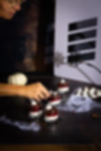 Foodstyling beim Halloween-Fotoshooting, Fotografin Christa Huber arrangiert Dessert mit Pinzette im Studio.