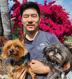 Dr. Fang holding two dogs