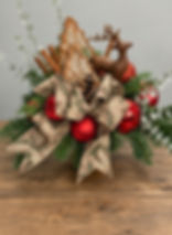 Christmas floral arrangement with reindeer and red ornaments