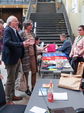 Eine Unterhaltung zwischen Ausstellenden und Bersucher*innen.