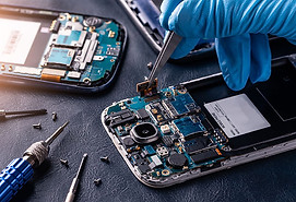 A gloved hand uses tweezers to repair a disassembled smartphone on a workbench, surrounded by tools and electronic components, conveying focus and precision
