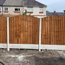 Wooden fence panels with white concrete bases in suburb