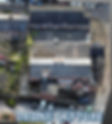 Aerial view of an urban scene with a large rooftop featuring two orange and white structures.