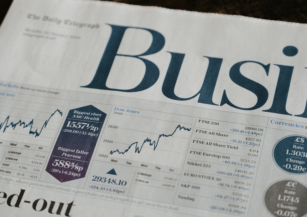 Newspaper business section showing stock market graphs and data. Prominent text: "Biggest riser NMC Health," "Biggest faller Pearson."