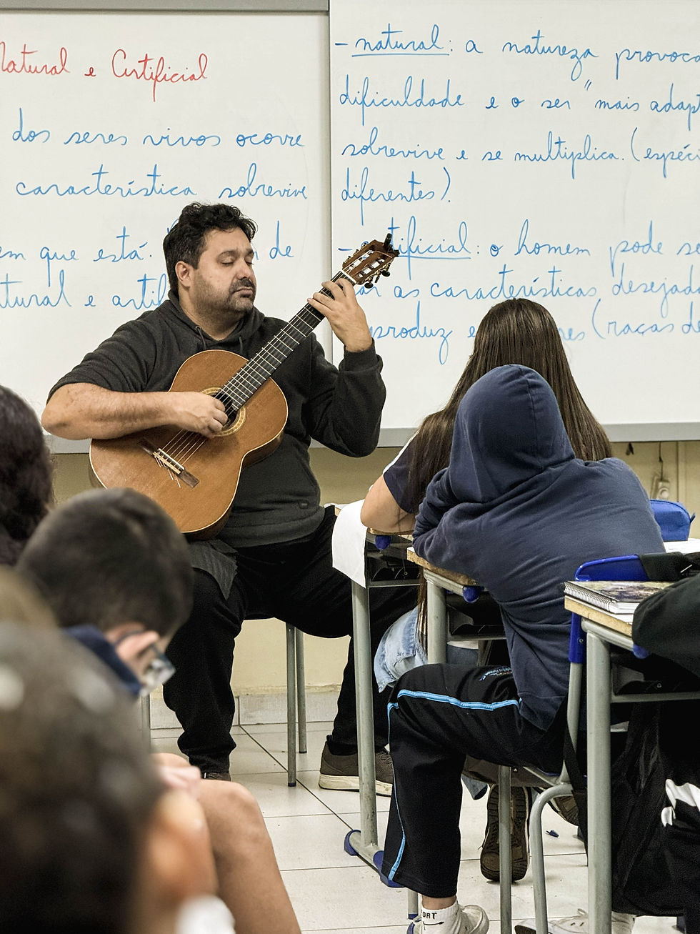 Professor toca instrumento na trajetória do Violão na Escola.