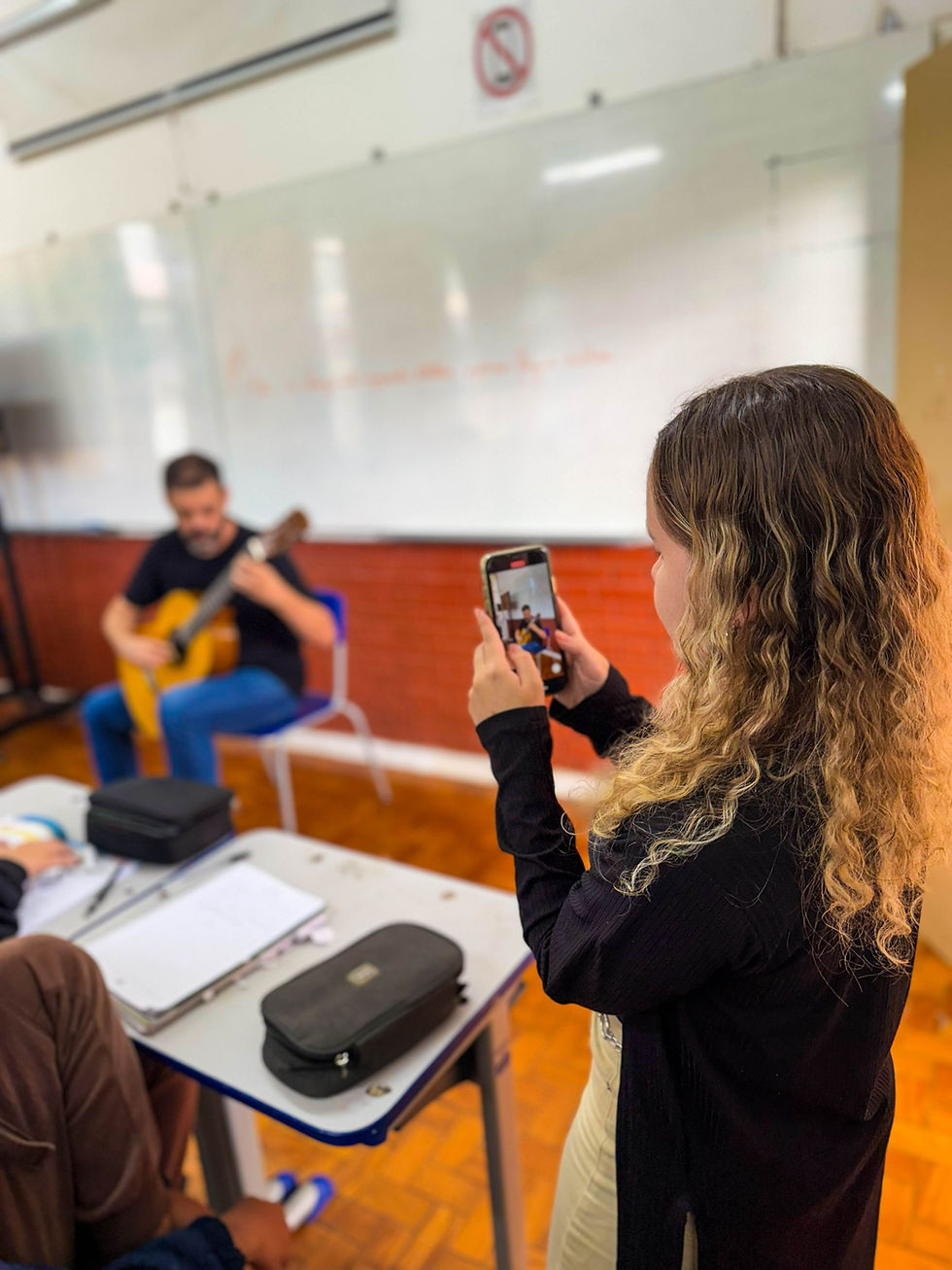 Aluna filma aula na trajetória do Violão na Escola.