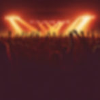 a large crowd silhouette at a concert with a lot of people reaching up.jpg