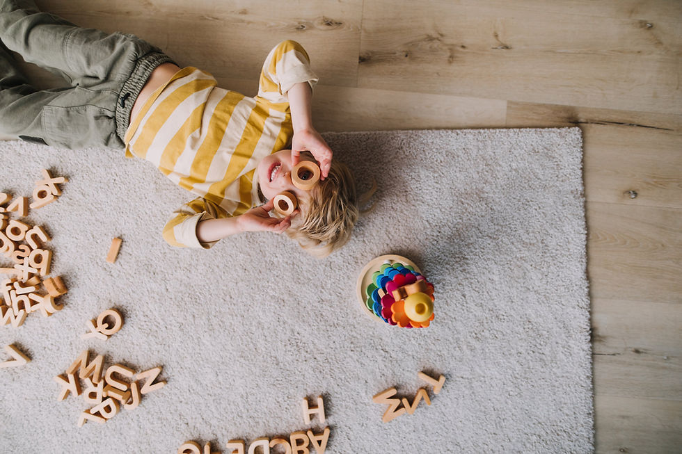 Child laying on floor looking at blocks