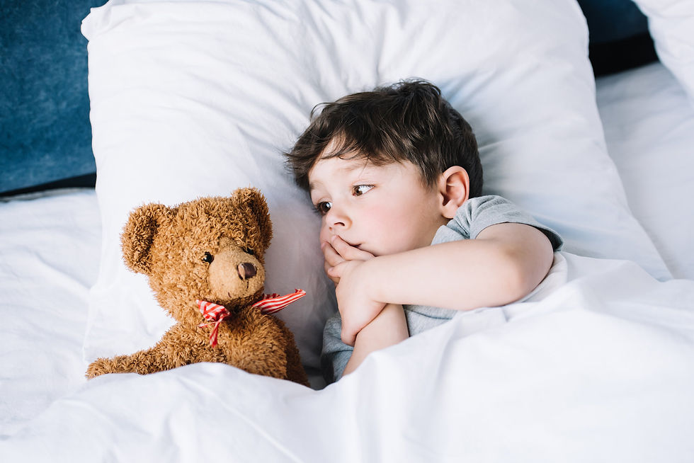 child in bed with teddy bear