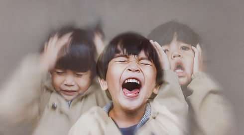 Triple-exposure photo of a screaming young boy with his hands on his head — illustrating dysregulation and overwhelm