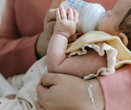 mother feeds her baby girl from a bottle