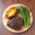 on a wooden cut board a grilled steak, baked sweet potato and grilled asparagus .jpg