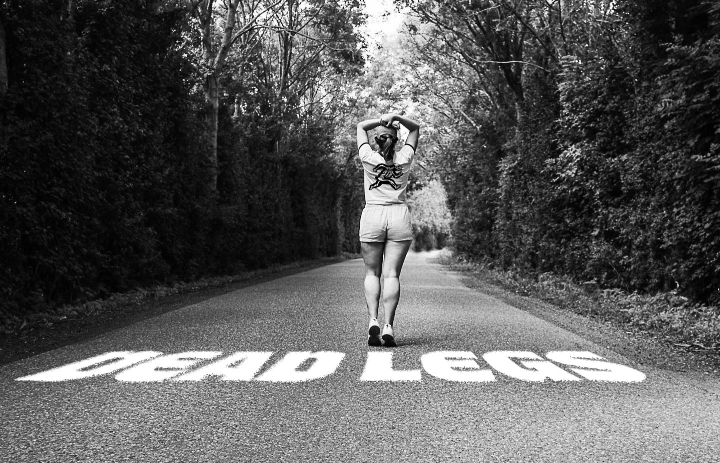 Runner walking mid-race with Dead Legs Run Club etched into the asphalt, part of a visual storytelling and endurance branding project by Overland Design Co in Las Vegas.
