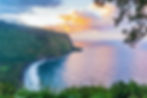 Sunset over Big Island coast as waves gently meet the shore.