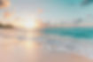 Golden sunset over a serene tropical beach with gentle waves, soft sand, palm trees, and pastel-colored sky.