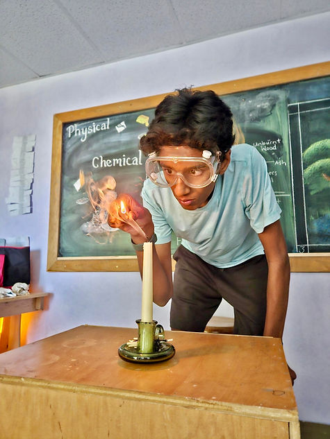 Middle school science experiment at Nevada Sage Waldorf School, featuring a student using safety goggles and exploring chemical reactions with a candle.