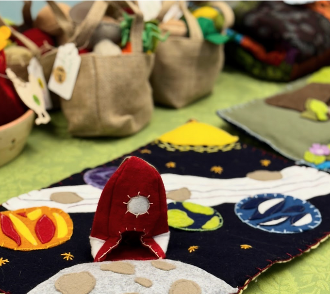 Close-up of a Waldorf market table at Nevada Sage Waldorf School, featuring colorful dried corn, handcrafted baskets, and natural crafts in Reno.
