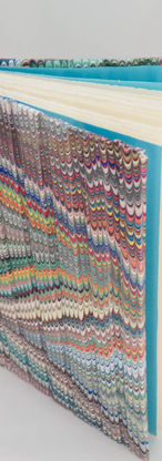 Multi-colored marbled book with ridges across the cover.