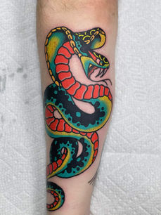 American traditional cobra tattoo in green, red and yellow on a forearm.