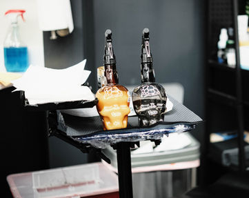 Skull ink bottles and tattoo machines on the artist tray at Cherno Ink Tattoo Studio