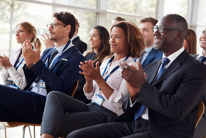 Grou pof people clapping as they listen to a presentation