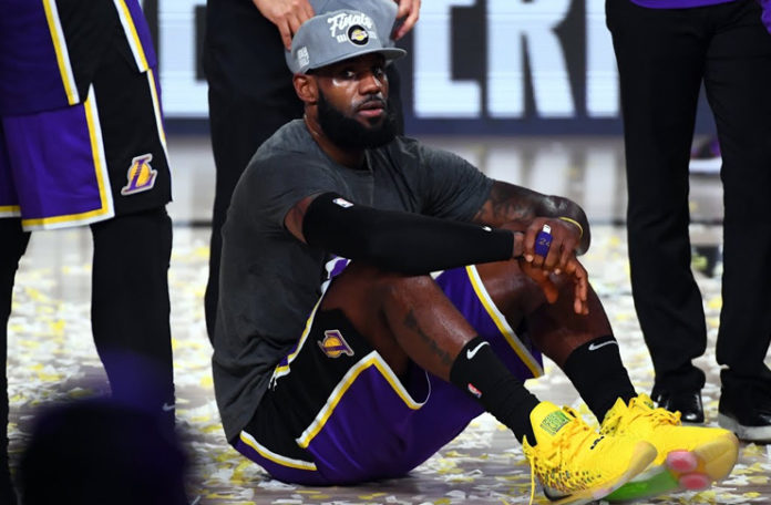 LeBron sitting down while his teammates celebrate as they win the Western Conference Finals (Credits: NBAE/Getty Images)