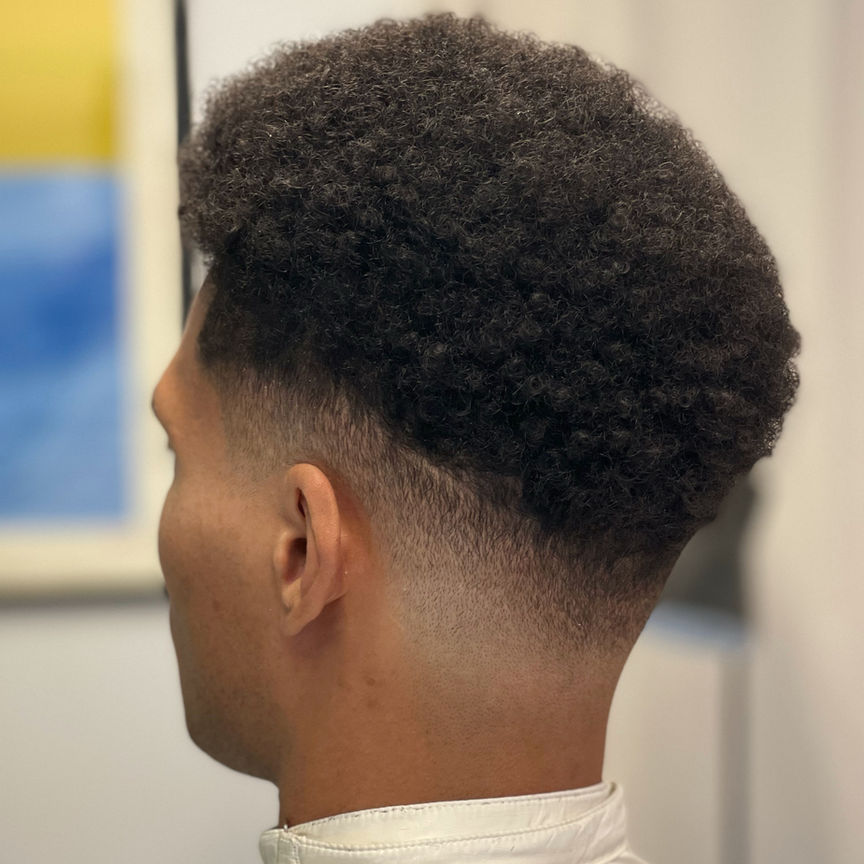 Curly afro top with low skin fade, side profile