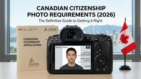 A close-up photograph of a black Canon EOS R digital mirrorless camera with an RF 24-70mm lens attached, sitting on a wooden desk. Next to it are a miniature Canadian flag desk stand and a booklet. The blurred background shows a Vancouver cityscape with mountains and water, and a person with a Canadian flag pin.