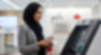 A smiling woman wearing a black hijab and grey blazer stands at an automated banking machine (ABM), holding a payment card. On the ABM, a white sticker displays text in English and French explaining CDIC deposit protection up to $100,000 CAD.