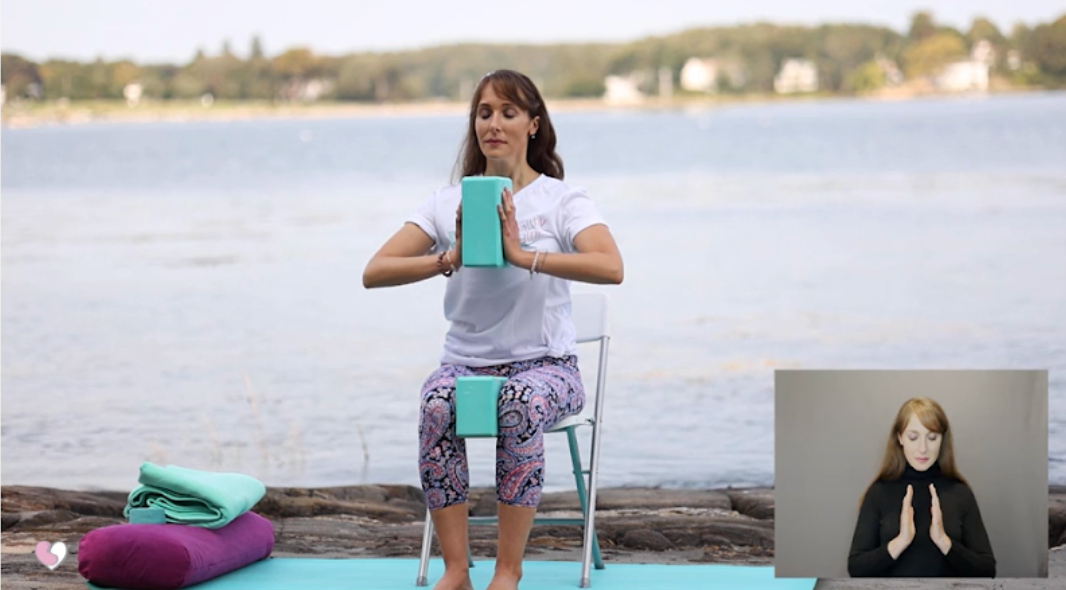 Bethany the Healthy Yogini squeezes yoga blocks between her hands and thighs