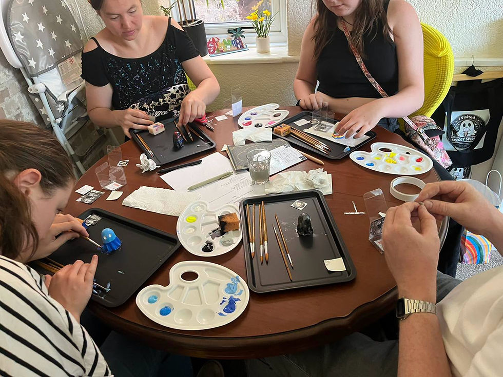 People at a Skeggy Spirits workshop painting figurines.