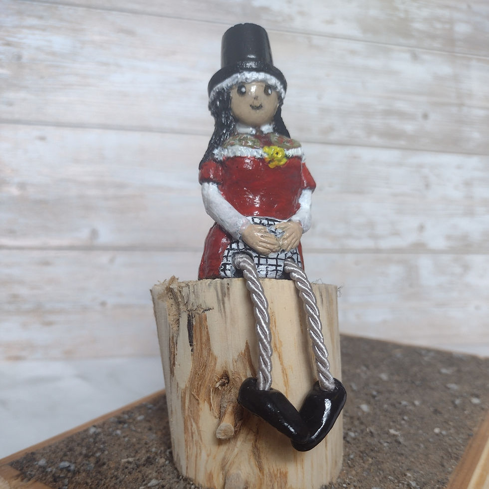 A decorative handmade doll in a traditional Welsh costume