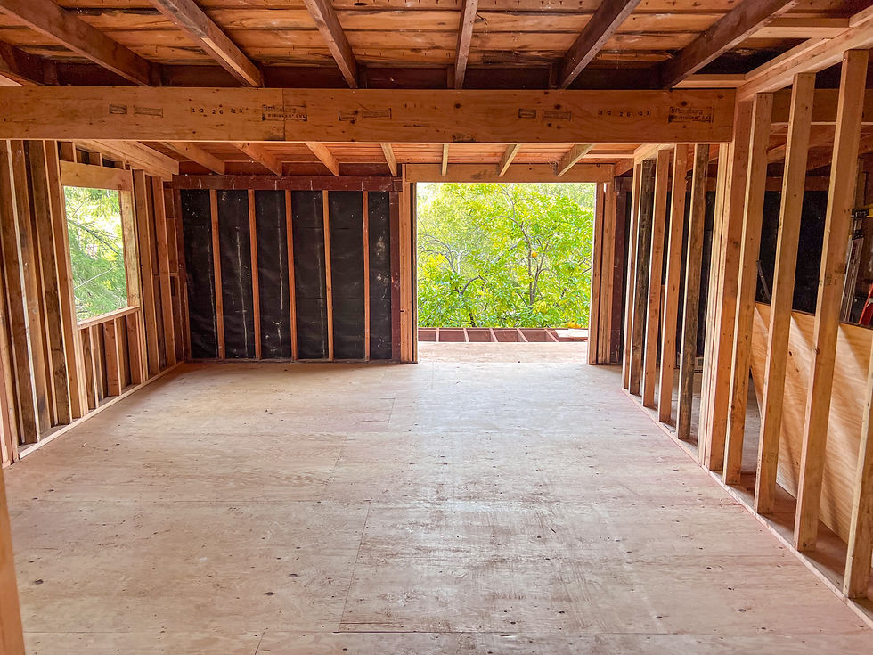 Eye-level view of a construction site with wooden framing in a forested area