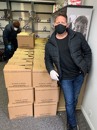 Volunteer at MAZON grantee standing in front of boxes wearing a mask