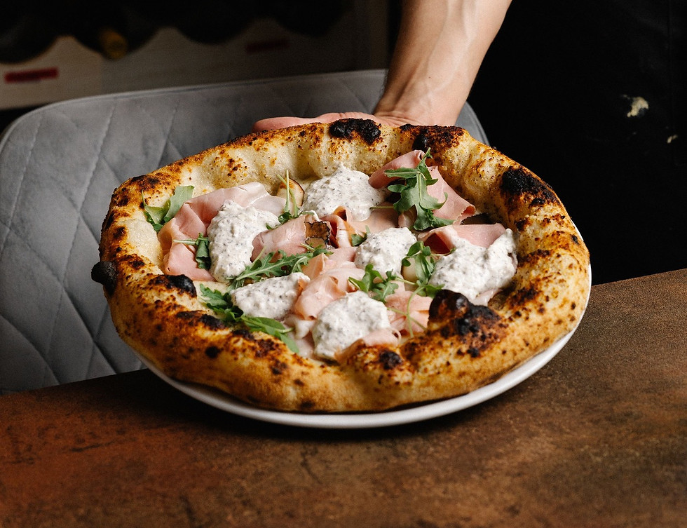 Photo d'une pizza artisanale fraîchement préparée au Bar à Pizza, mettant en valeur la qualité des ingrédients et le savoir-f