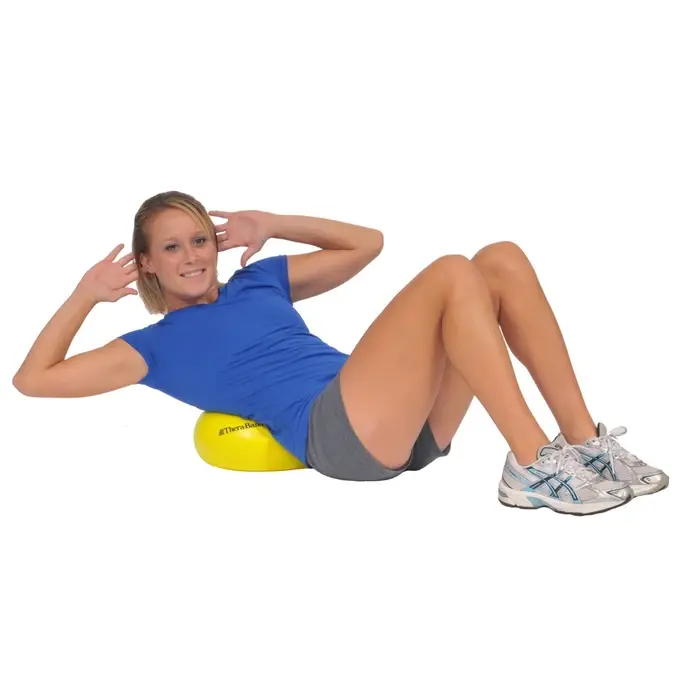 Patient squeezing a TheraBand Mini Ball between their knees during physical therapy core exercises